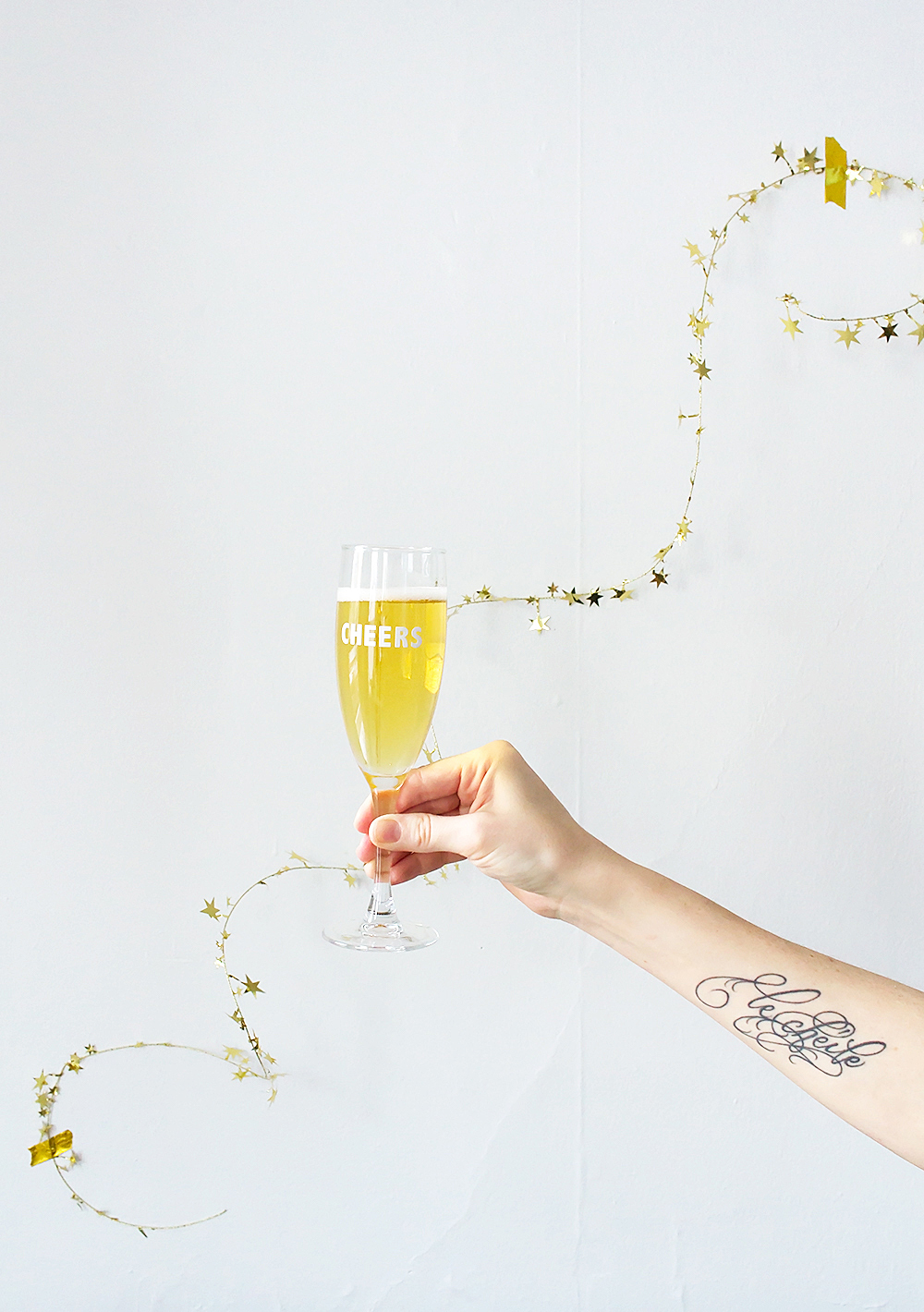 Get festive with this 5 minute New Year's Eve party hack. These DIY Cheers Champagne Flutes are super quick, and all you need are stickers!