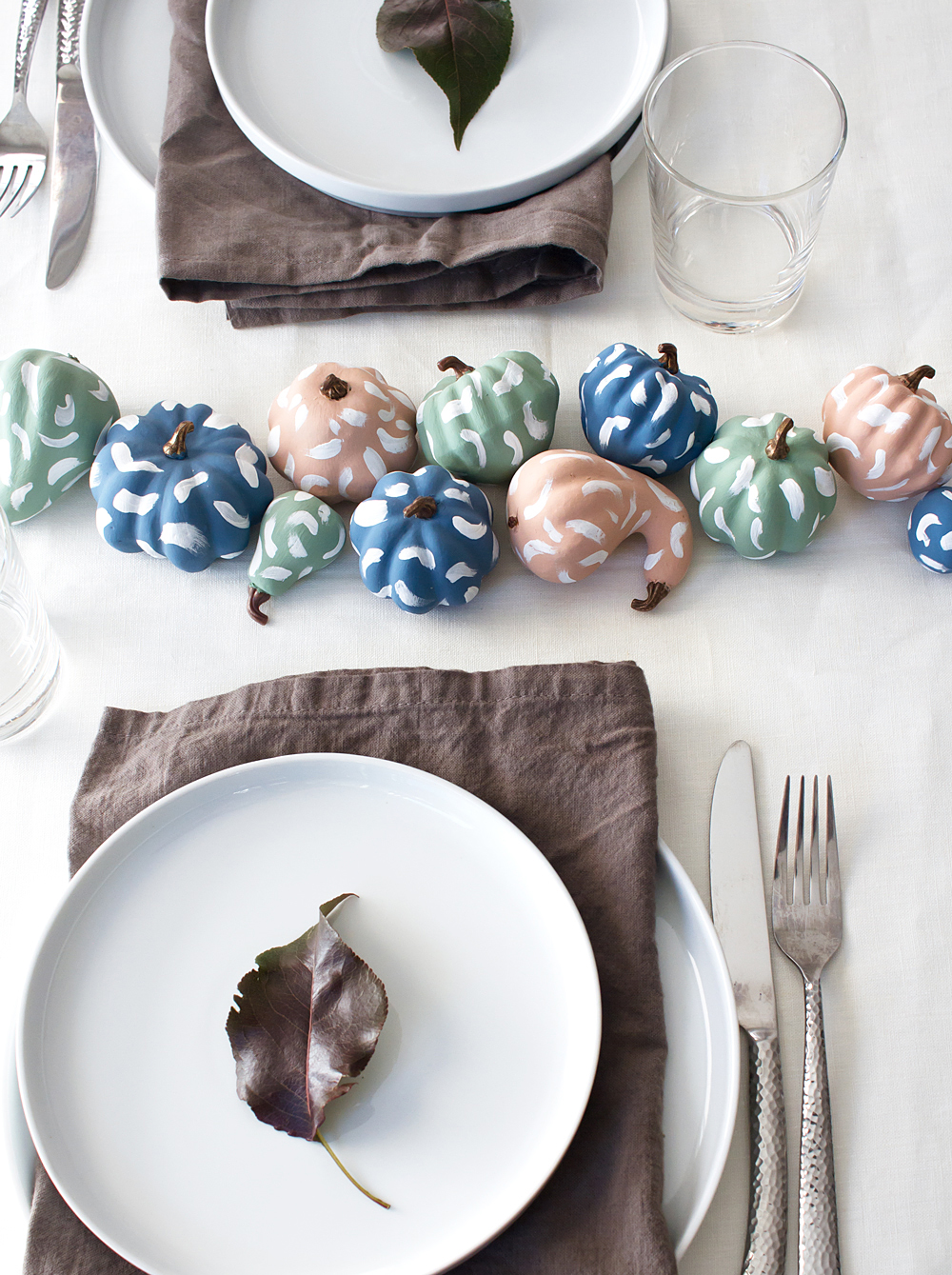 These easy DIY pastel brushstroke pumpkins make a beautiful Thanksgiving centerpiece, and would be fun for a colorful Halloween too! Click through for the free tutorial.